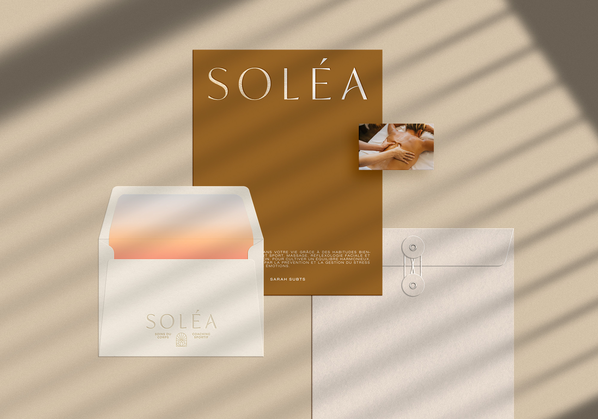 Logo de Soléa appliqué sur des supports imprimés, comprenant une enveloppe et une carte de visite, pour une première impression élégante et douce.